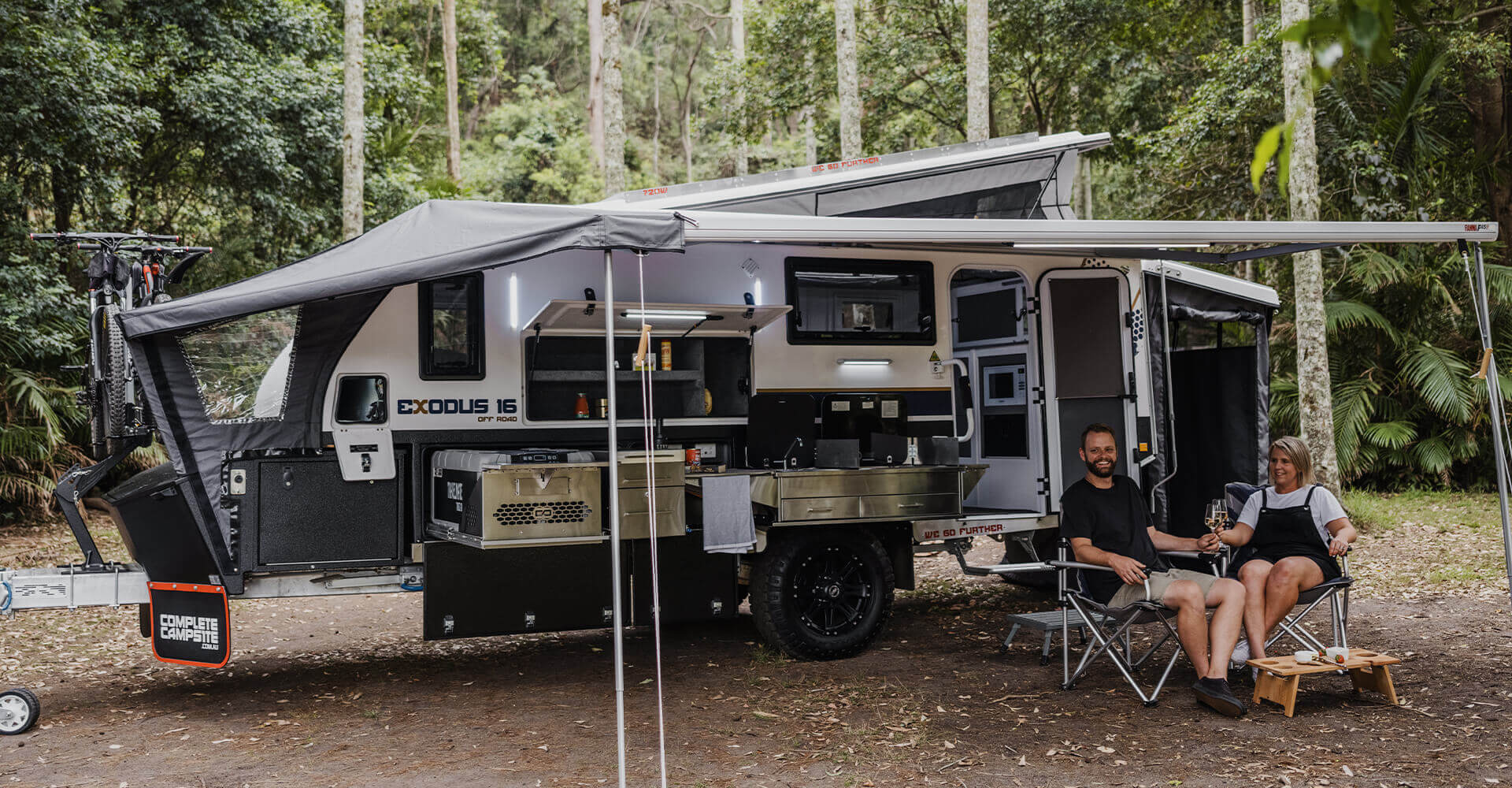 Couple drinking a wine in their camper trailer.